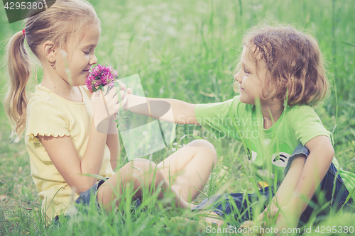 Image of Two happy children  playing near the tree at the day time.