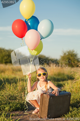 Image of Happy little girl playing on road at the day time.