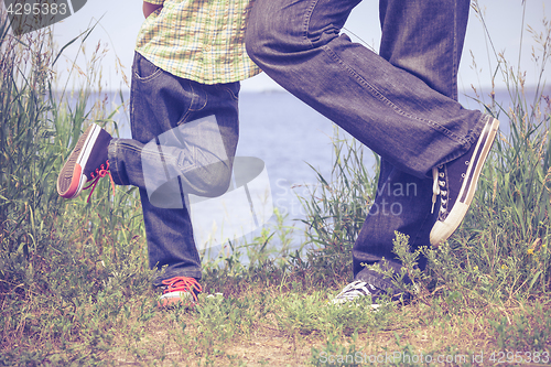 Image of Father and son playing at the park near lake at the day time.