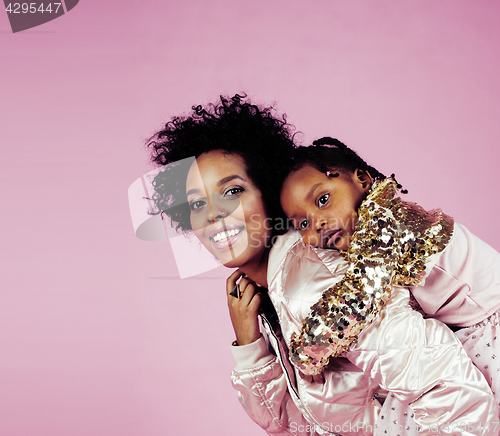 Image of young pretty african-american mother with little cute daughter hugging, happy smiling on pink background, lifestyle modern people concept