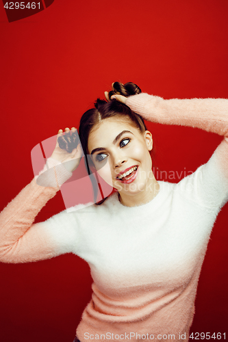 Image of young pretty emitonal posing teenage girl on bright red background, happy smiling lifestyle people concept closeup