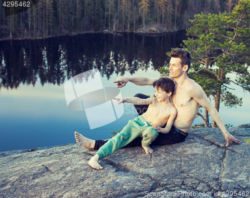 Image of middle age man with little cute son doing sport yoga on the top of the mountain together, happy family lifestyle people outdoor, summer wild nature for training 