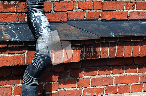 Image of old drainpipe on a brick wall