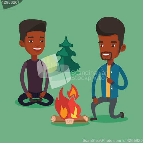 Image of Two friends sitting around bonfire in camping.