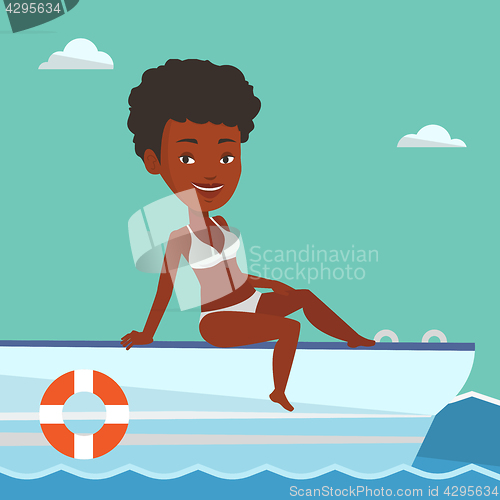 Image of Young happy woman tanning on sailboat.