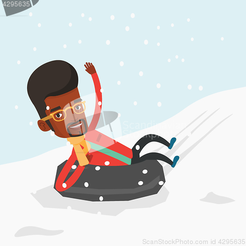 Image of Man sledding on snow rubber tube in mountains.