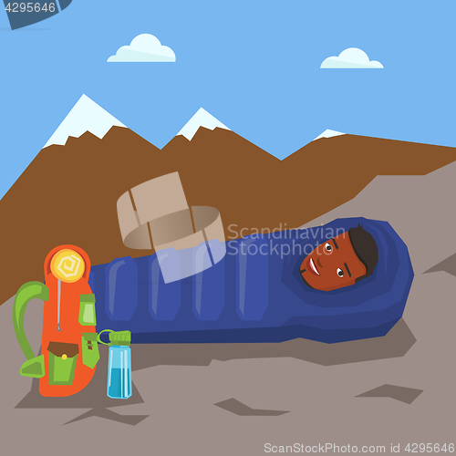 Image of Man resting in sleeping bag in the mountains.