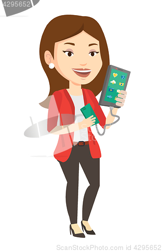 Image of Woman reharging smartphone from portable battery.