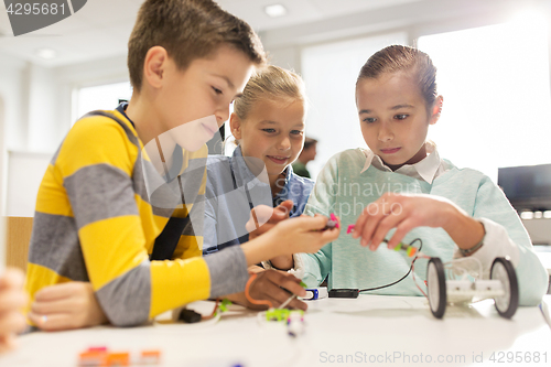 Image of happy children building robots at robotics school