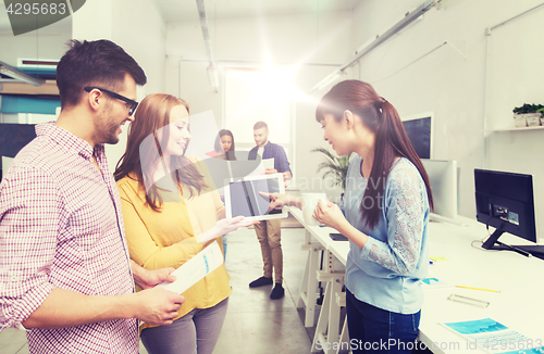 Image of creative team with tablet pc talking at office