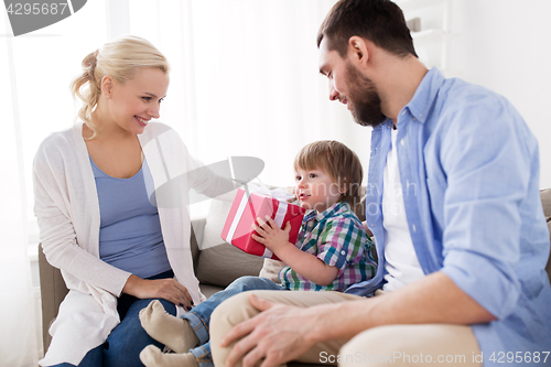 Image of happy family with birthday gift at home