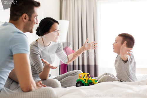 Image of happy family in bed at home or hotel room