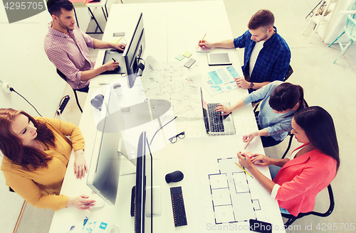 Image of creative team with computers, blueprint at office