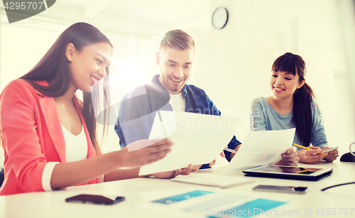 Image of happy creative team or students working at office