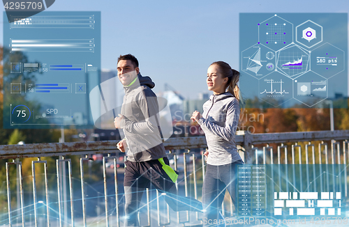 Image of happy couple running outdoors