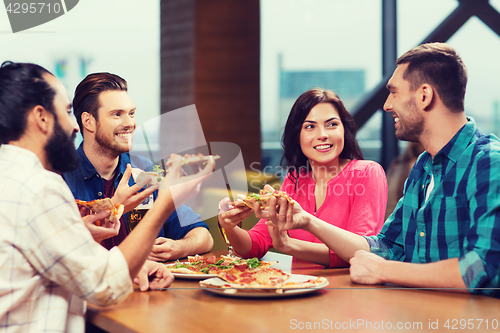 Image of friends eating pizza with beer at restaurant