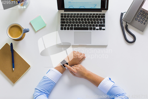 Image of hands of businesswoman working on laptop at office