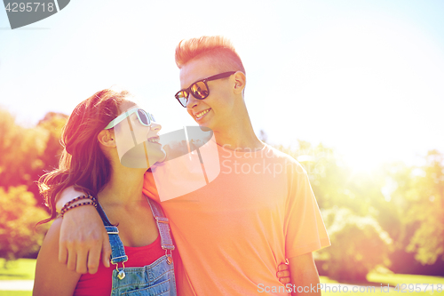 Image of happy teenage couple looking at each other in park