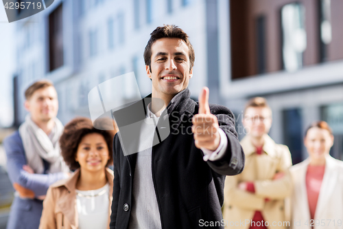 Image of international business team showing thumbs up
