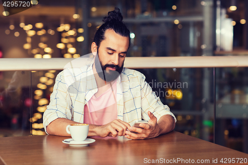 Image of man with smartphone and coffee at restaurant