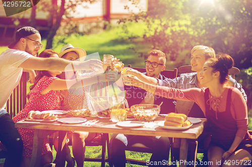 Image of happy friends having dinner at summer garden party