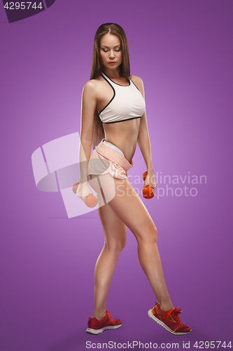 Image of Muscular young woman athlete posing at studio