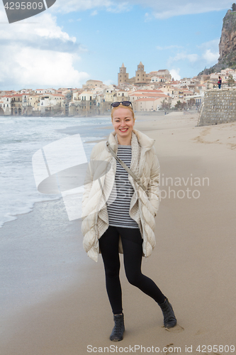 Image of Woman on empty beach of Cefalu in winter time, Sicily, south Italy.