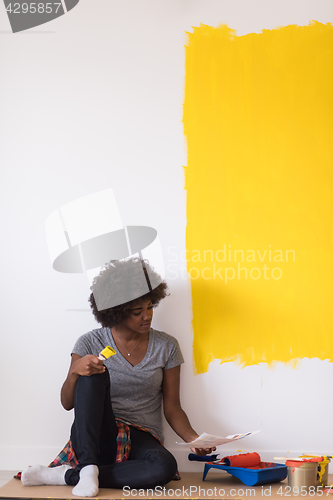 Image of back female painter sitting on floor