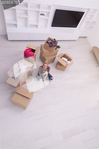 Image of woman with many cardboard boxes sitting on floor