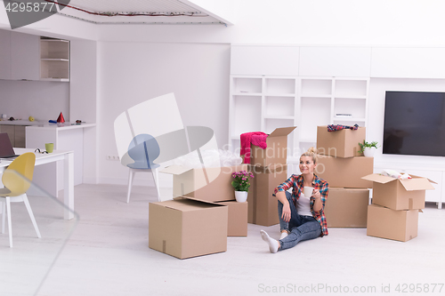 Image of woman with many cardboard boxes sitting on floor