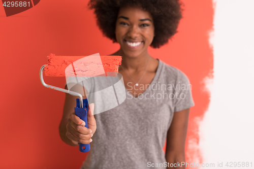 Image of black woman painting wall