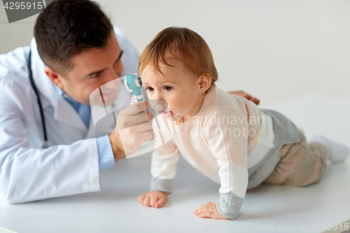 Image of doctor with otoscope checking baby ear at clinic