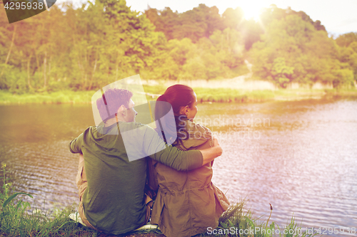 Image of happy couple hugging on lake or river bank