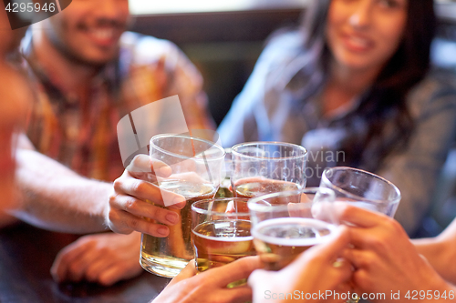 Image of happy friends drinking beer at bar or pub