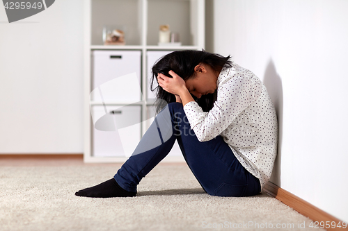 Image of unhappy woman crying on floor at home