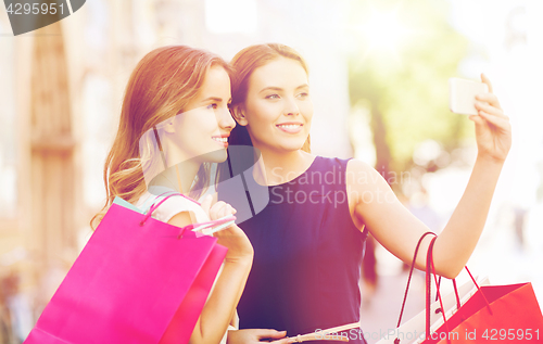 Image of happy women with shopping bags and smartphone