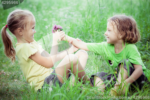 Image of Two happy children  playing near the tree at the day time.