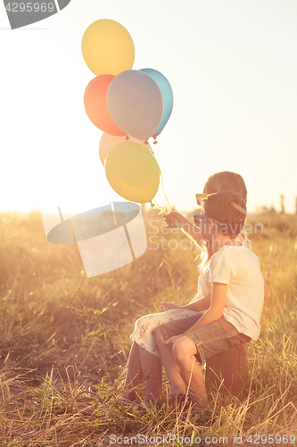 Image of Happy child playing on the field at the sunset time.