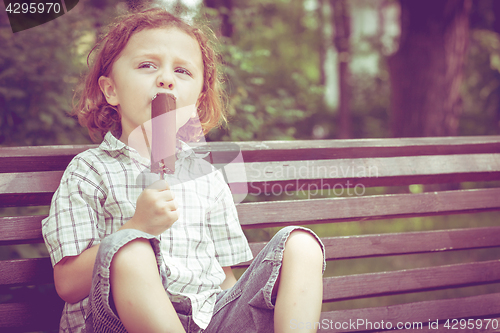 Image of little boy eating ice cream in the park