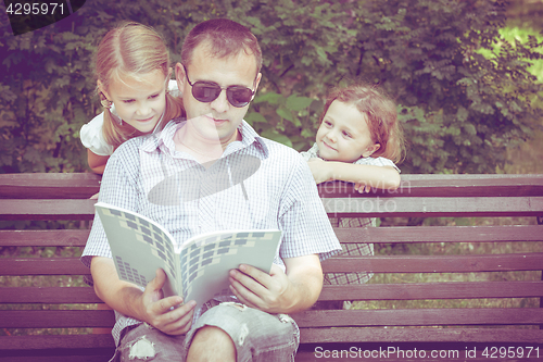 Image of Father and children playing on the bench at the day time.