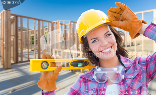 Image of Female Construction Worker Holding Level Wearing Gloves, Hard Ha