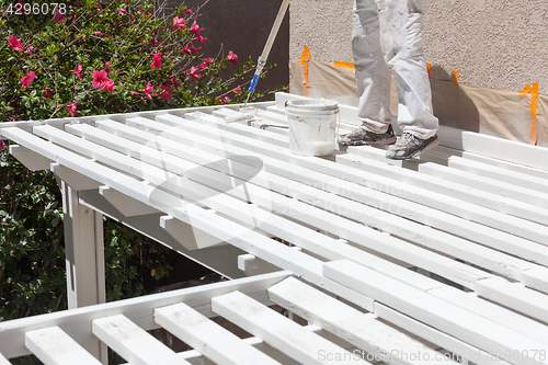 Image of Professional Painter Rolling White Paint Onto The Top of A Home 