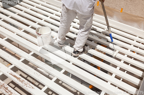 Image of Professional Painter Rolling White Paint Onto The Top of A Home 