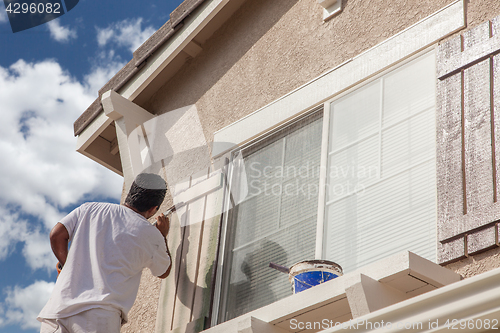 Image of Professional House Painter Painting the Trim And Shutters of A H