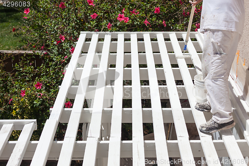 Image of Professional Painter Rolling White Paint Onto The Top of A Home 