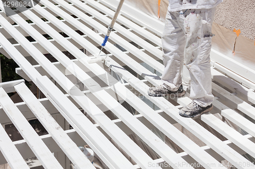 Image of Professional Painter Rolling White Paint Onto The Top of A Home 