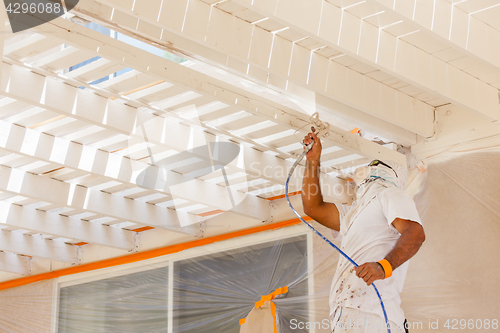 Image of Professional House Painter Wearing Facial Protection Spray Paint