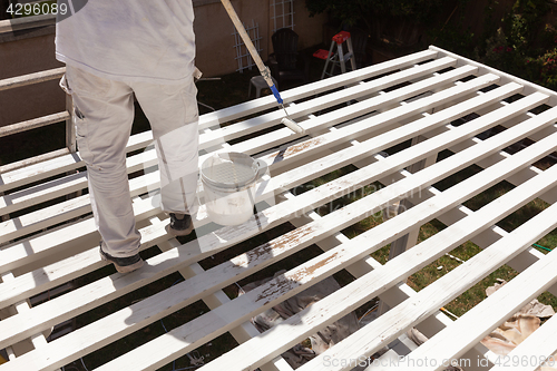 Image of Professional Painter Rolling White Paint Onto The Top of A Home 