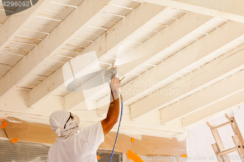 Image of Professional House Painter Wearing Facial Protection Spray Paint