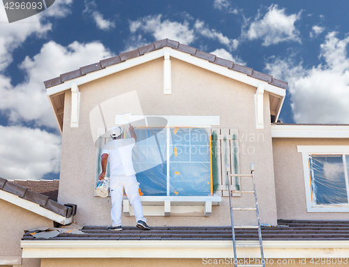 Image of Professional House Painter Painting the Trim And Shutters of A H